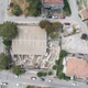 An aerial image of an archaeological site, bordered by modern buildings on all sides.
